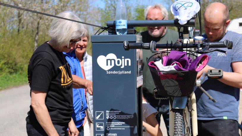 Grå bikestation bruges af fire personer