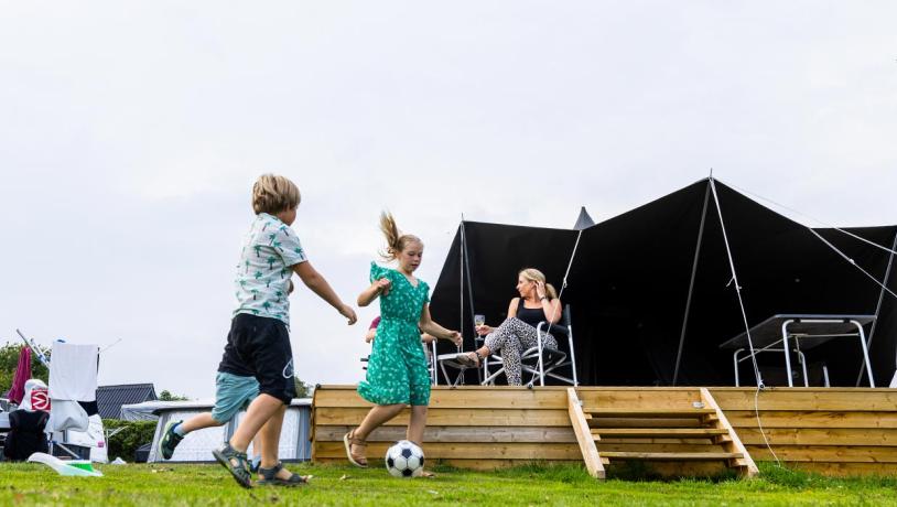 Børn spiller bold foran MOJN telt på Lærkelunden Camping