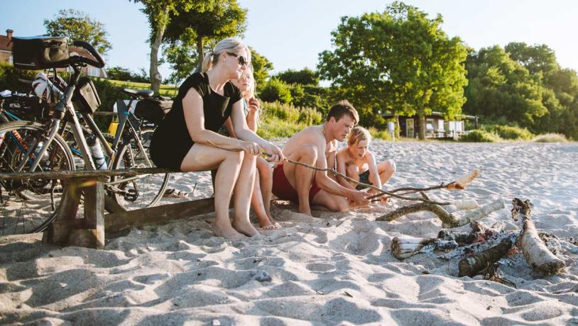 Familie på stranden med bål og cykler