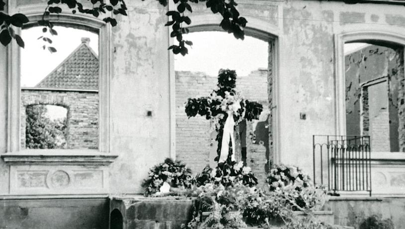 Paludan-Müller mindekors smykket med rødbøg og hvide bånd