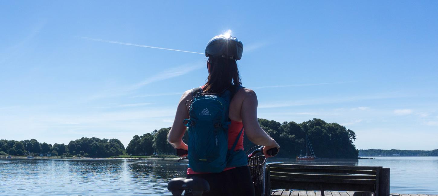 Kvinde med cykel kigger på Okseøerne i Flensborg Fjord