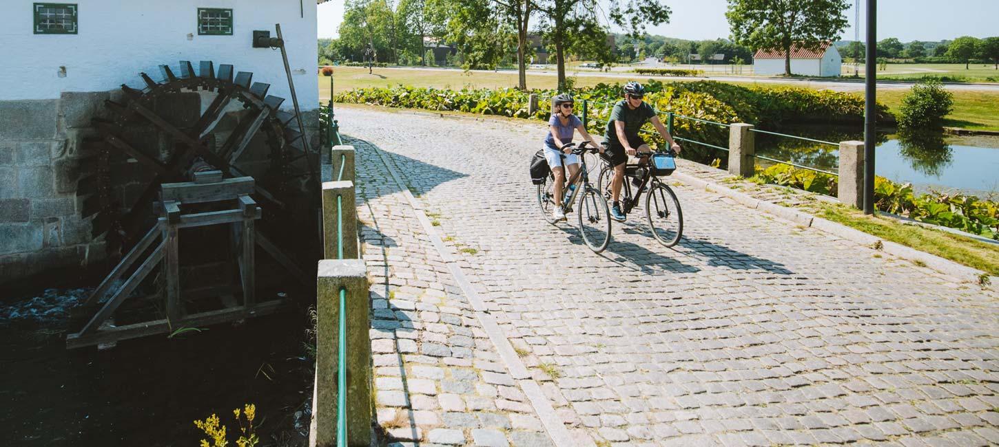 Pärchen fährt Fahrrad an der alten Schlossmühle in Aabenraa