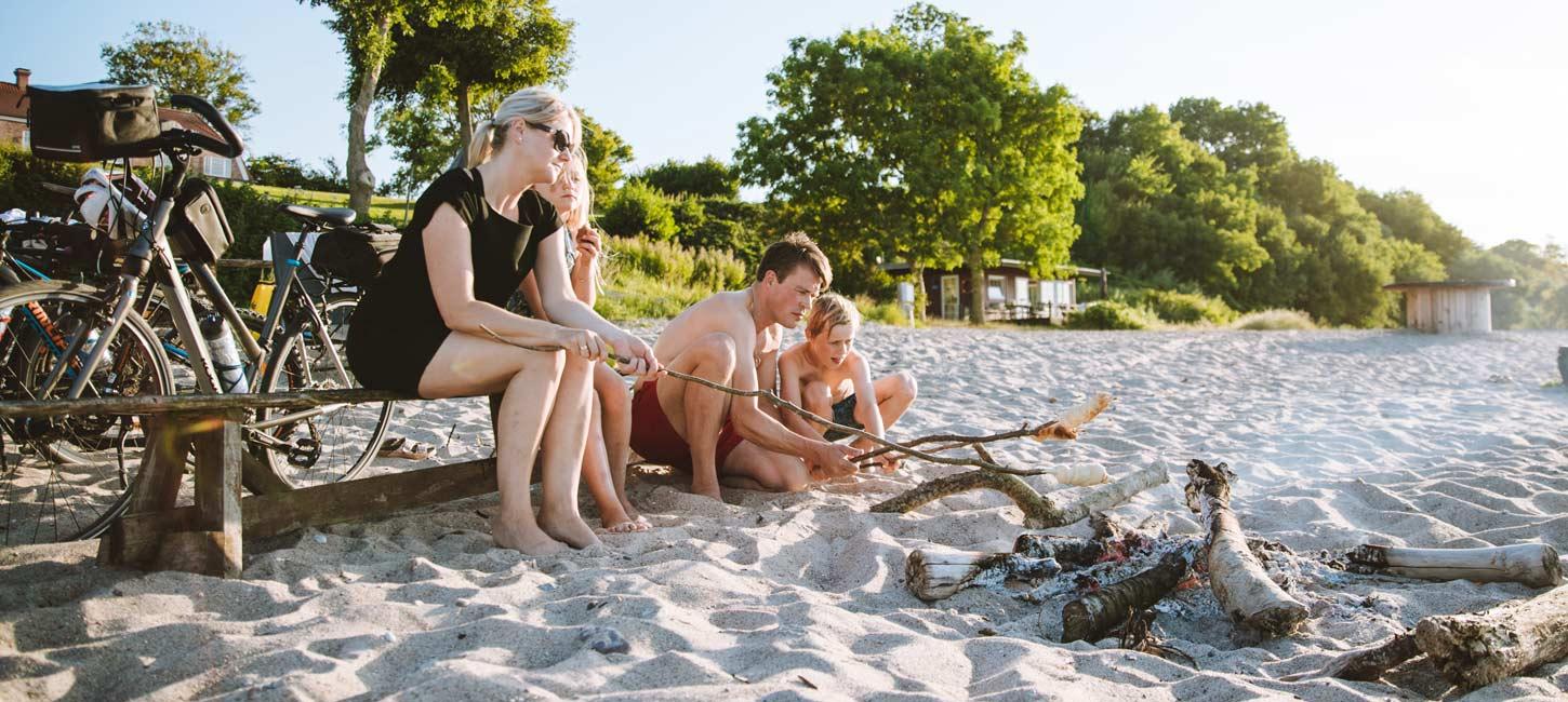 Familie på stranden med bål og cykler