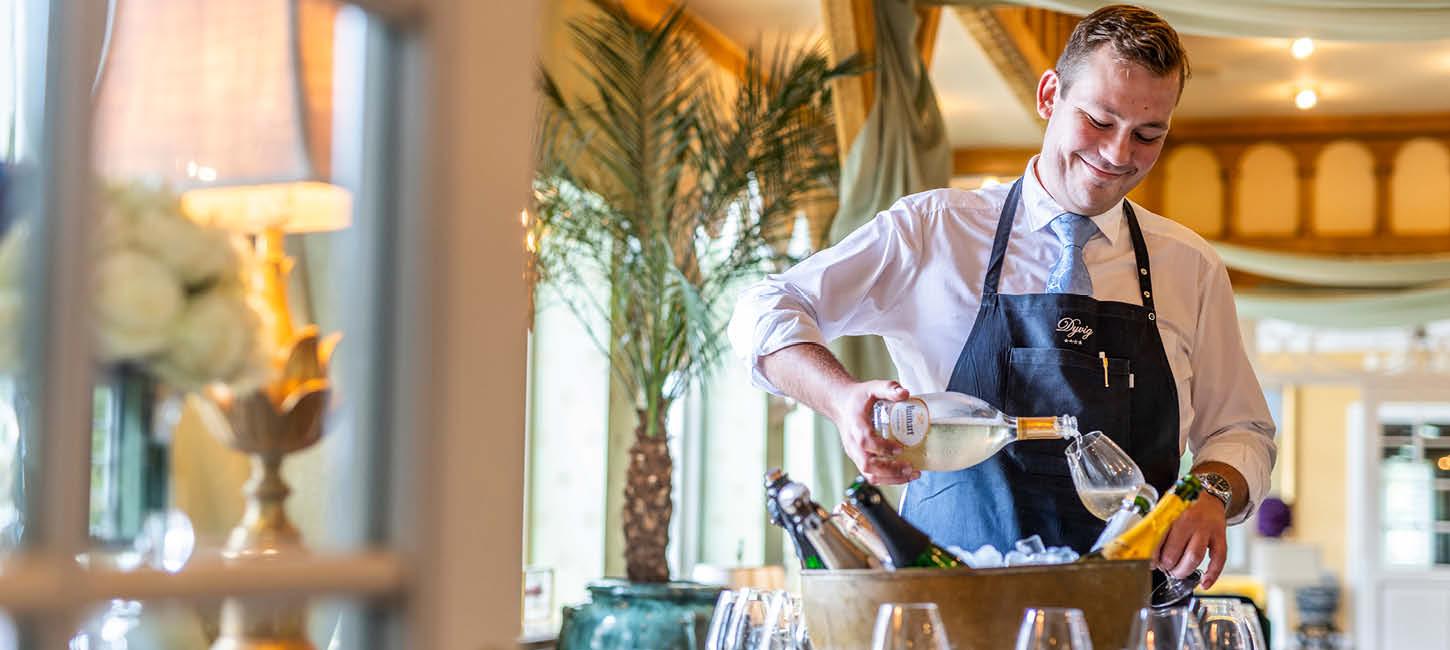 Tjener skænker vin på Dyvig Badehotel