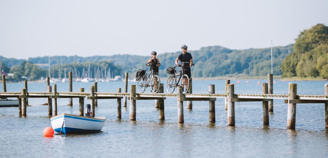 Par med cykler på bro ved Genner Strand