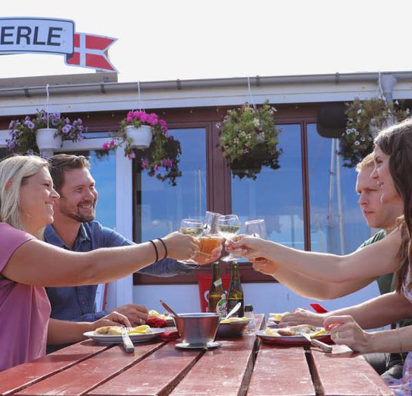 Gæster skåler ved Aarøs Perle på havnen på Årø