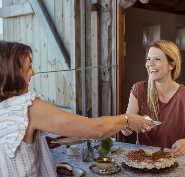To kvinder hygger og griner til Sønderjysk kaffebord på Klægager
