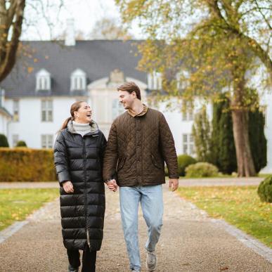 Par vandrer i slotshaven ved Schackenborg Slot i efteråret