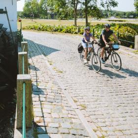 Pärchen fährt Fahrrad an der alten Schlossmühle in Aabenraa