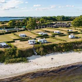 Dronefoto af Drejby Strand Camping med strand og vand på begge sider