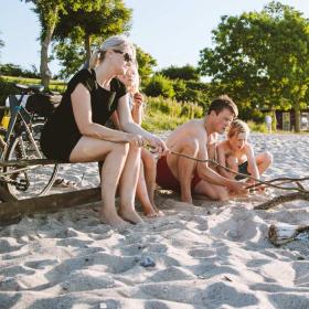 Familie på stranden med bål og cykler