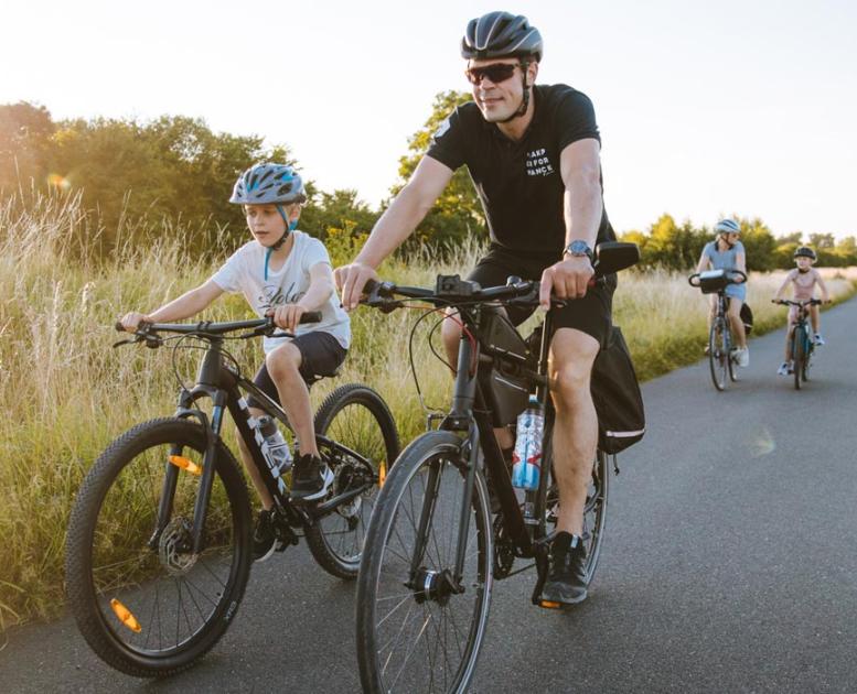 Cyklende familie på lang lige landevej på Kær Halvø