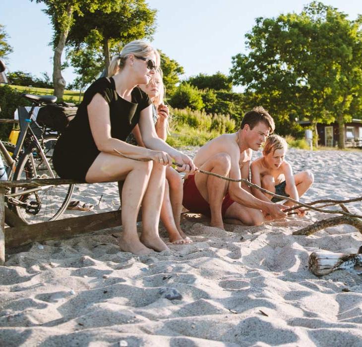 Familie på stranden med bål og cykler